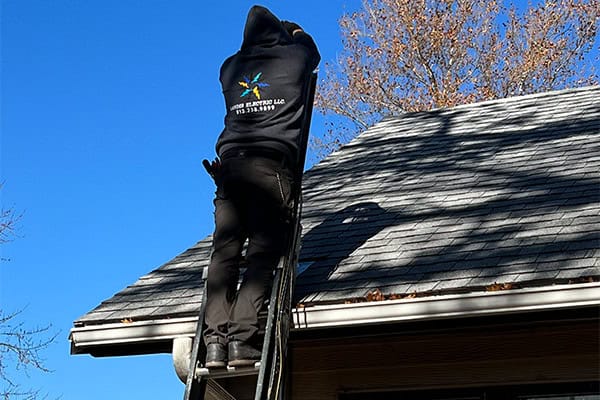 Electrician Working On Roof Ladder Residential Home Safety
