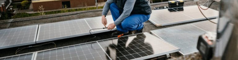 worker installing solar panels on a roof